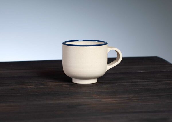 espresso cup with navy rim on dark base, front view