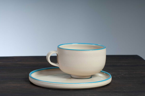 front view of cappuccino cup and saucer set with blue rim