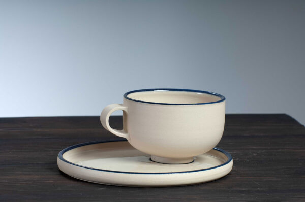 front view of cappuccino cup and saucer set with navy rim