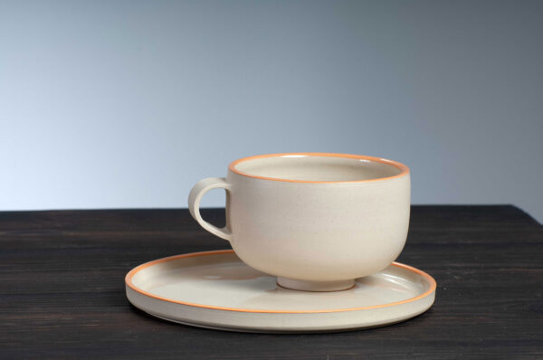 front view of cappuccino cup and saucer set with orange rim