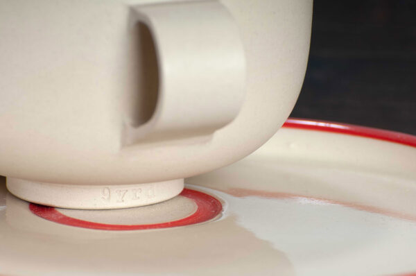 detail view of cappuccino cup and saucer set with red rim