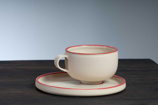 front view of cappuccino cup and saucer with red rim