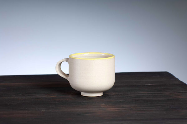 front view of coffee cup with yellow rim